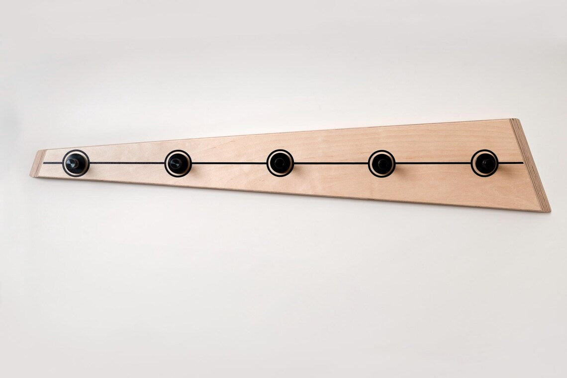 Minimalist wooden coat hook mounted on a white wall, ideal for modern home decor.