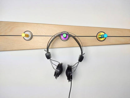 Versatile wall-mounted wooden hook used as a key holder, towel rack, and coat hanger.